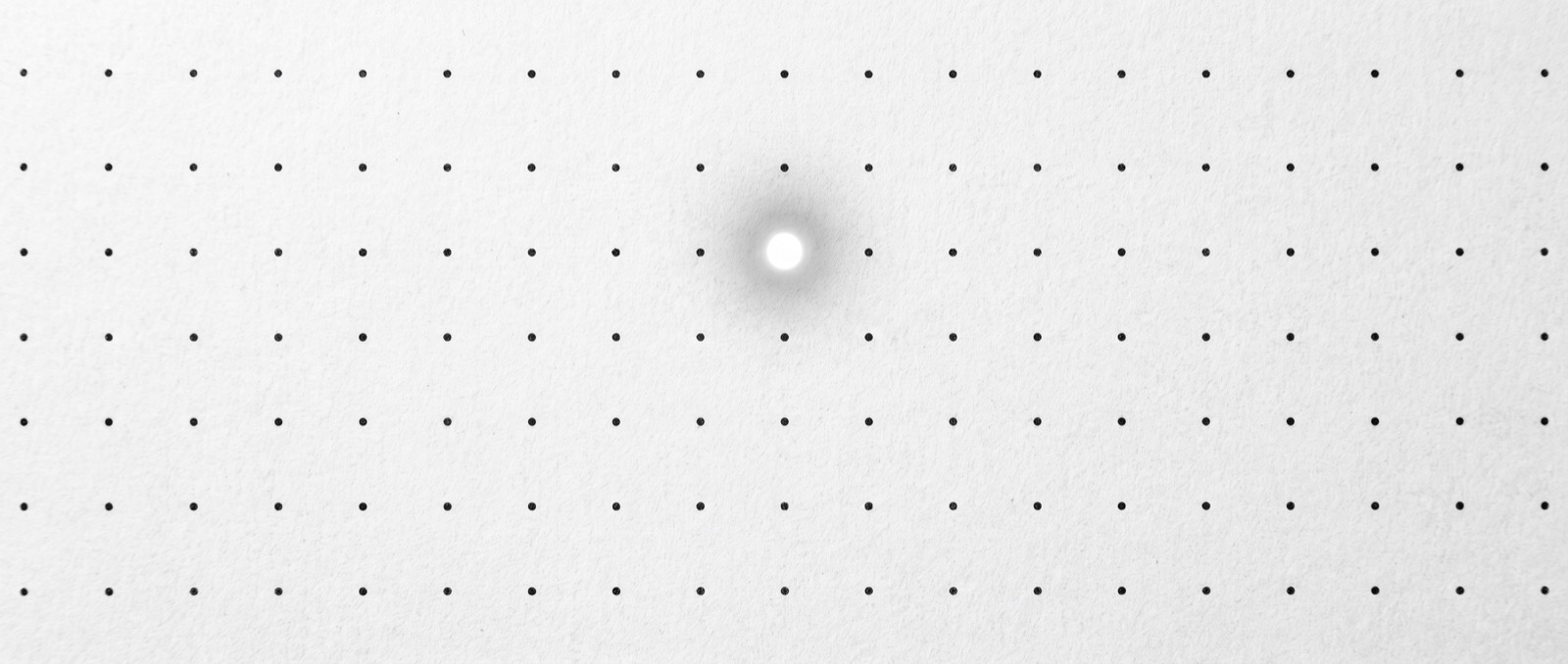 A field of identical dots with one lit